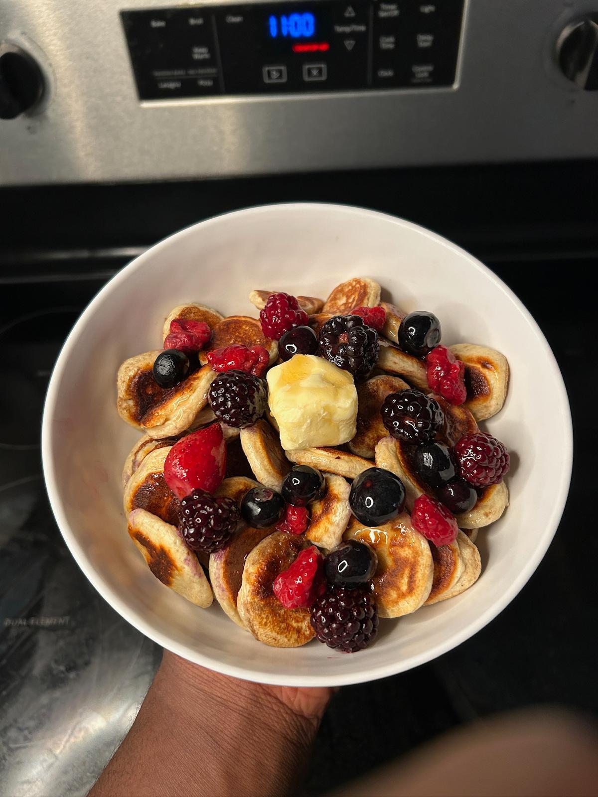 Pancakes served with strawberries and orange slices